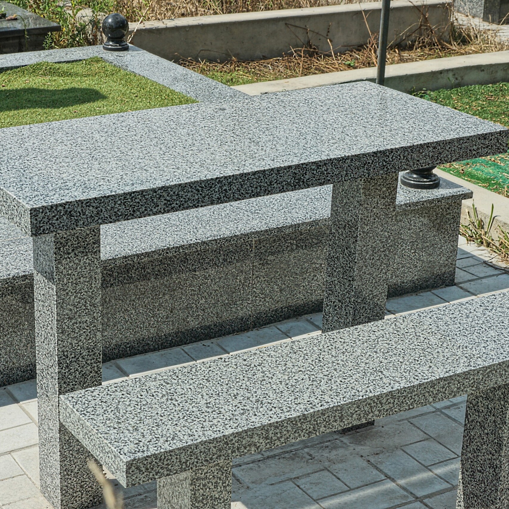 gray bench and table of stone and marble at the grave in the cemetery